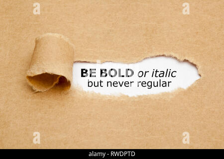 Inspirational quote Be Bold Or Italic But Never Regular appearing behind torn paper. Concept about the importance of being different and standing out  Stock Photo