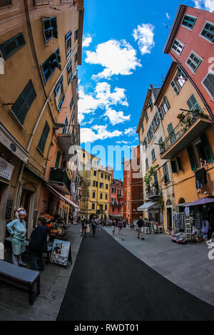 walking down the streets of Italy, with traditional italian colored buildings in the background and local people Stock Photo