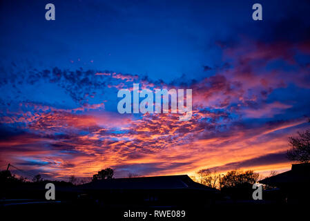The magnificent deep blue color of the sky and golden yellow and orange of the clouds after sunset. Stock Photo