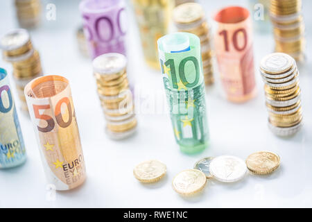 Rolled euro banknotes and coins towers stacked in other positions Stock Photo