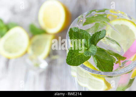 Lemonade with ice and fresh lemon with mint on wooden background. horizontal view. copy space. refreshing summer drink. Stock Photo