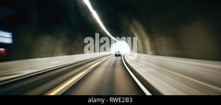 A motion blurred car traveling through a road tunnel. Stock Photo