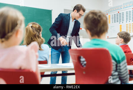 Teacher handing back written tests to the class Stock Photo