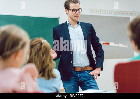 Teacher standing in front of students in school class Stock Photo