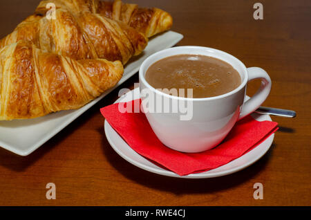 Breakfast : hot chocolate sauce with croissants, and orange juice, on a wooden table Stock Photo