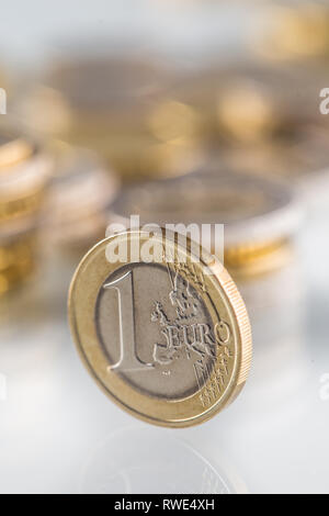 Euro coin balances on another coin and several loose coins
