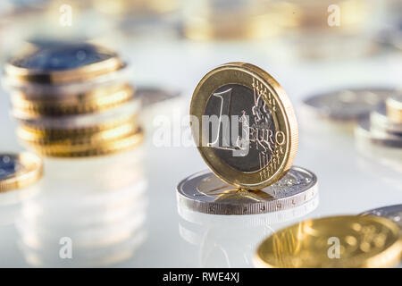 Euro coin balances on another coin and several loose coins