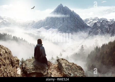 Woman enjoying the view from the top of a mountain Stock Photo