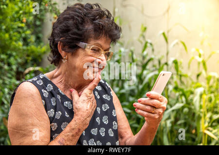 happy elderly woman using cellphone Stock Photo