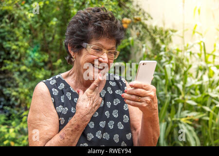 happy elderly woman using cellphone Stock Photo