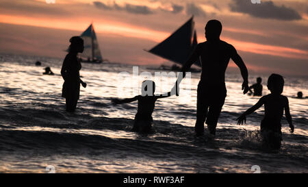 Family Vacation Silhouette in Water on Sunset Beach - Boracay Island, Panay - Philippines Stock Photo