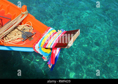 Bow of a orange and blue colourful fishing boat with flower decorations, Phuket, Thailand. Stock Photo