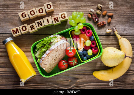 School lunch box with sandwich, vegetables, water, and fruits on table.  Healthy eating habits concept Stock Photo - Alamy