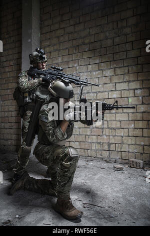 Pair of Army Rangers with rifle and machine gun moving along the ...