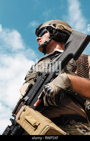 Low angle portrait of U.S. Army Ranger with machine gun, looking up to sky. Stock Photo