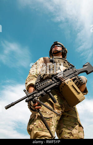 Low angle portrait of U.S. Army Ranger with machine gun, looking up to sky. Stock Photo