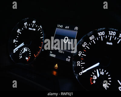 Car dashboard with speedometer showing 0 kilometres per hour stand in traffic jam queue with 10000 KM mark milestone Stock Photo