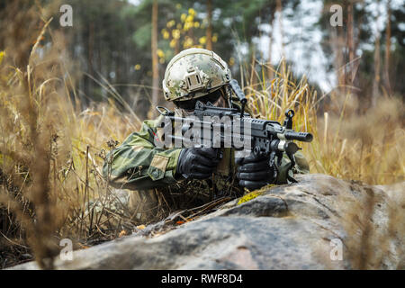 Norwegian Rapid reaction special forces FSK soldier firing in the forest. Stock Photo