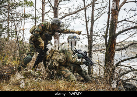 Norwegian Rapid reaction special forces FSK soldiers scouting in the forest trees. Stock Photo