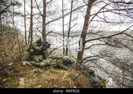 Norwegian Rapid reaction special forces FSK soldiers scouting in the forest trees. Stock Photo