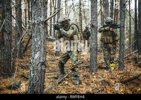 Norwegian Rapid reaction special forces FSK soldiers patrolling in the forest trees. Stock Photo