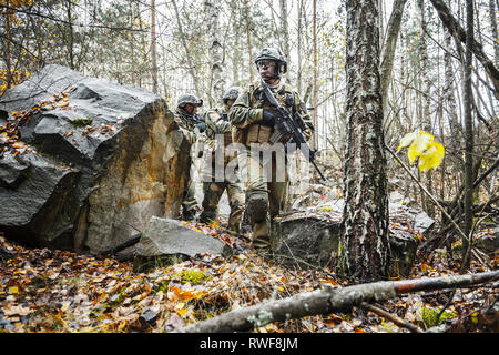 Norwegian Rapid reaction special forces FSK soldiers patrolling in the forest trees. Stock Photo