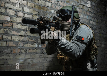 Special forces operator pointing weapon in the dark. Stock Photo