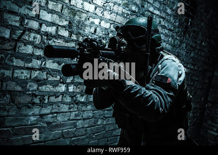 Special forces operator pointing weapon in the dark. Stock Photo