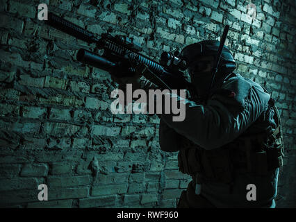 Special forces operator pointing weapon in the dark. Stock Photo