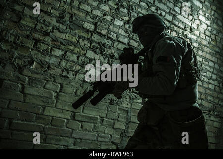 Special forces operator pointing weapon in the dark. Stock Photo