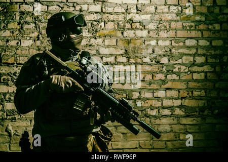Special forces operator pointing weapon in the dark. Stock Photo