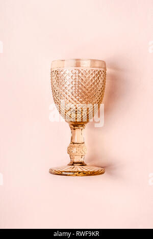 Luxurious golden Vintage Wine Glass on pastel pink background. Stock Photo