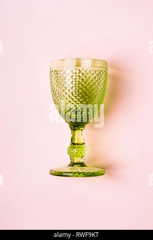 Luxurious green Vintage Wine Glass on pastel pink background. Stock Photo