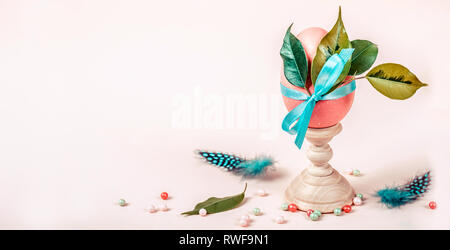 Easter composition with decorated egg on stand. Banner format. Stock Photo