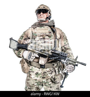 Low angle portrait of muscular soldier in field uniform with machine gun. Stock Photo