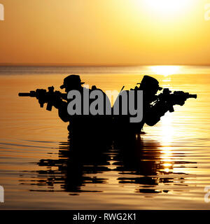 Silhouette of Army soldiers crossing a river against an orange