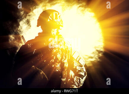 Special forces soldier with assault rifle and searchlight in background. Stock Photo
