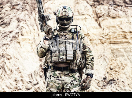 Elite fighter of special forces standing with service rifle, ready for battle. Stock Photo