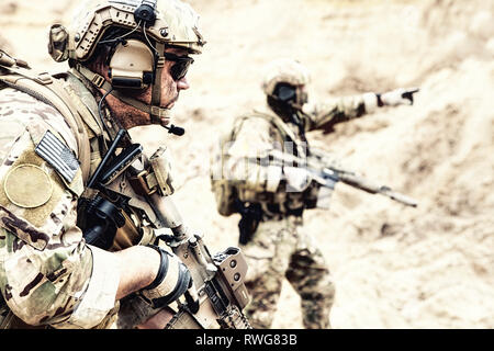 U.S. special operations forces moving forward with caution in the desert during a reconnaissance mission. Stock Photo