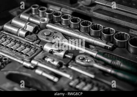 Flat Lay metal tools: wrenches, ratchet, a set of interchangeable heads of different sizes and other tools are in the tool box, a top view. Close-up C Stock Photo