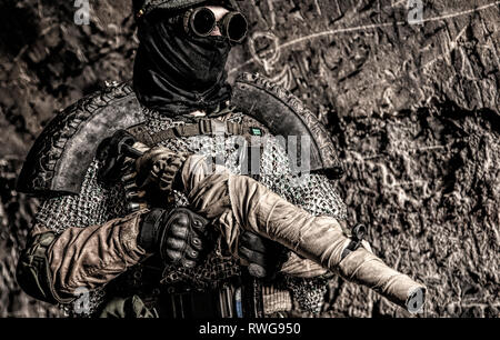 Post apocalyptic soldier with handmade gun and body armor in an abanonded bunker. Stock Photo