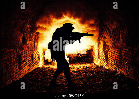 Silhouette of post apocalyptic soldier shooting weapon in underground sewage tunnel. Stock Photo