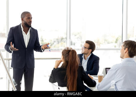 African business coach in suit giving presentation to clients Stock Photo