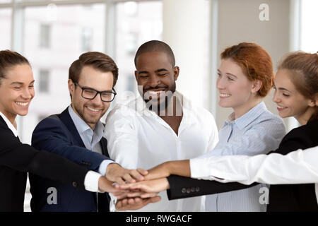 Diverse business people group put hands together in stack pile Stock Photo