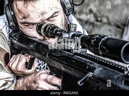 U.S. Navy SEAL sniper in firing position armed with large caliber sniper rifle. Stock Photo