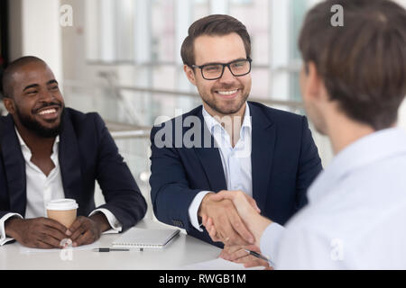Positive diverse business partners shaking hands starting meeting Stock Photo