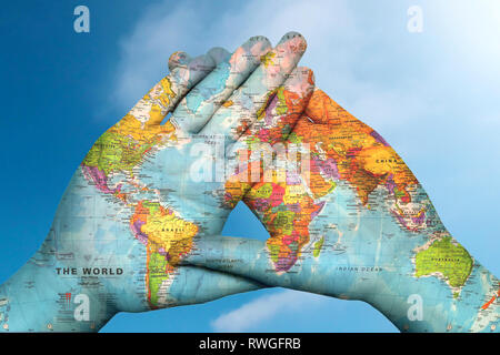 world map in hands against the sky Stock Photo