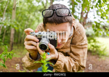 Brunet biologist in glasses photographs plants Stock Photo