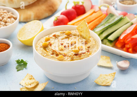 Hummus and variety of vegetable sticks and chips. Healthy snacks. Stock Photo