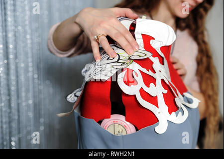 Female fashion designers put templates of dresses on mannequins. Stock Photo